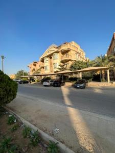 um edifício com carros estacionados ao lado de uma rua em The GlassHouse Pool no Cairo