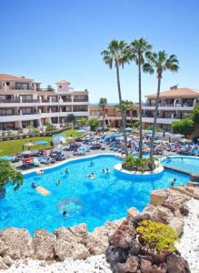a large swimming pool with people in a resort at Sunshine Apartments in San Miguel de Abona
