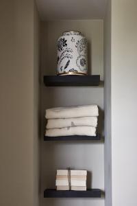 Zimmer mit Regalen mit Handtüchern und Vase in der Unterkunft Brasserie Spoorhuis Mijdrecht in Mijdrecht