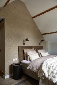 een slaapkamer met een bed met twee lampjes aan de muur bij Brasserie Spoorhuis Mijdrecht in Mijdrecht