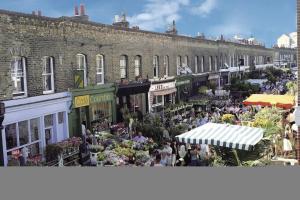a crowd of people walking around an outdoor market at Shoreditch apartment with lovely garden in London