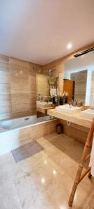 a bathroom with two sinks and a tub and a mirror at Panoramic Sea Views - Penthouse in Quartiers in Estepona