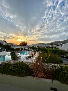 uitzicht op een zwembad met zonsondergang op de achtergrond bij Relux Ios Hotel in Ios Chora