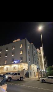 a large building with a truck parked in front of it at Manazel Al Faisal Furnished Apartments in Al Baha