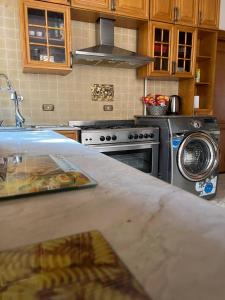 a kitchen with a stove and a washing machine at The GlassHouse Pool in Cairo