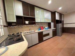 a kitchen with white cabinets and a stove top oven at Muslim Suite Home @ Airport Bayan Lepas Penang in Bayan Lepas