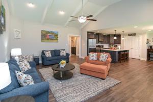 a living room with blue couches and a kitchen at Quiet Family Home 15 Mi to Dtwn Huntsville! in Hazel Green