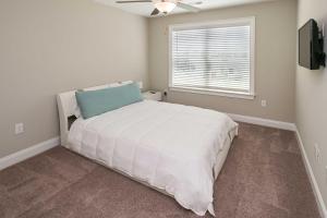 a bedroom with a white bed and a window at Quiet Family Home 15 Mi to Dtwn Huntsville! in Hazel Green