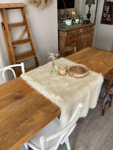 uma mesa de madeira com uma toalha de mesa branca em les chambres de pauline em Albertville