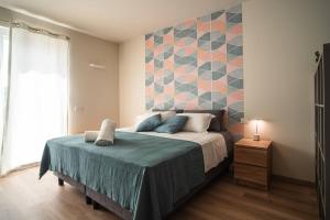 1 dormitorio con 1 cama con pared de azulejos en Monolocale Moderno Valpolicella Verona - Vayu, en San Pietro in Cariano