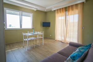 a living room with a table and a couch at Stella Marina Apartment - Sea View, close to the beach in Agnone Bagni