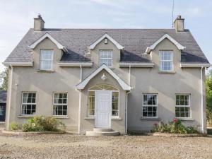 une maison avec une porte blanche devant elle dans l'établissement Craiglea Cottage, à Coleraine