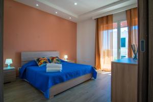 una camera con un letto blu e una finestra di Stella Marina Apartment - Sea View, close to the beach ad Agnone Bagni