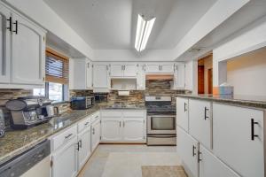 Una cocina blanca con gabinetes y electrodomésticos blancos. en Ski, Hike and Fish Big Bear Lake Home with Fire Pit, en Big Bear Lake