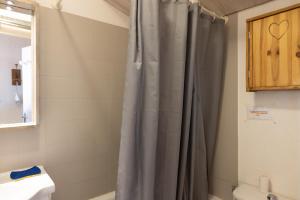 y baño con cortina de ducha y lavamanos. en Gai Soleil, en Saint-Gervais-les-Bains