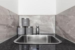 a kitchen sink with two cups on top of it at Serviced Ensuite Room Finsbury Park London N19 in London