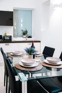 una mesa de comedor con sillas y platos. en Valletta Center Apartment, en La Valeta