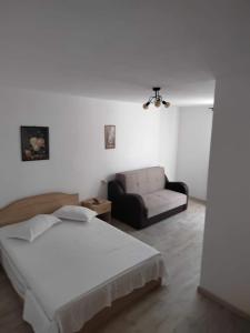 Habitación blanca con cama y sofá en CasaMarinela, en Orşova