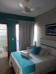 a bedroom with a bed with blue and white at Pousada Antares in São Thomé das Letras