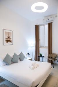 uma cama branca num quarto com uma janela em Valletta Center Apartment em Valeta