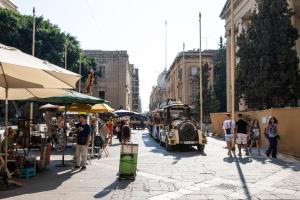 a group of people walking on a street with a bus at Valletta Center Apartment by Arco Collection in Valletta