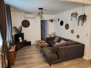 uma sala de estar com um sofá e uma mesa em GÎTES MA&LIA SUD ARDÈCHE em Saint-Étienne-de-Fontbellon
