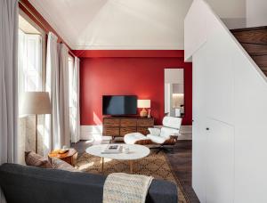 Almada 234 في بورتو: غرفة معيشة حمراء مع أريكة وتلفزيون