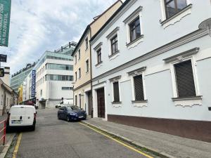 un'auto parcheggiata in una strada accanto a un edificio bianco di Apartment Blue House - Old Town, AC a Bratislava