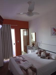 a bedroom with a bed and a ceiling fan at Pousada Antares in São Thomé das Letras