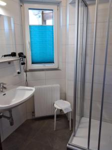 a bathroom with a shower and a sink and a window at Dolomitenhotel Lienz in Lienz