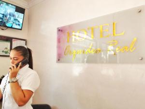 a woman talking on a cell phone in a room at Hotel Orquídea Real in Valledupar