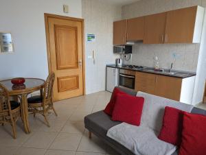 a kitchen and a living room with a couch and a table at Vila Cabral 1 Bed Apt - Wi-Fi & Air Con Included in Sal Rei