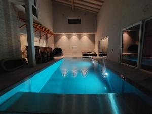 賽尼厄萊吉耶的住宿－Chambres de la Tuilerie，一座带蓝色泳池的大楼里的大型游泳池