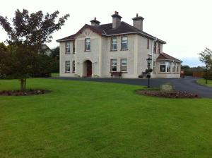 a large house with a green lawn in front of it at Quignalegan House in Ballina