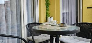 Cette chambre dispose d'une petite table et de chaises. dans l'établissement Cozy apartment - 2 bedrooms in the best city area., à Ferizaj