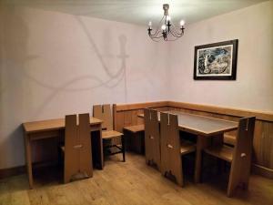 a dining room with wooden tables and chairs and a chandelier at Magnifique T4 pied des pistes in Risoul