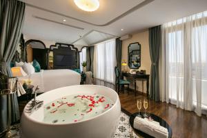 una habitación de hotel con una bañera llena de flores rojas en Grand Sunrise Palace Hoi An en Hoi An
