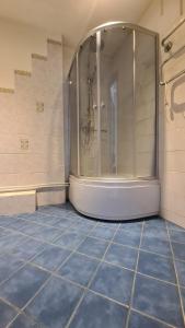 La salle de bains est pourvue d'une douche et de carrelage bleu. dans l'établissement Spacious Condo 5 min to Jurmala Beach, à Jurmala