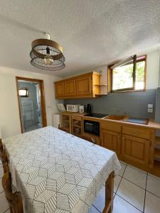 - une cuisine avec une table et un lit dans l'établissement Maison Ste Foy Tarentaise, à Sainte-Foy-Tarentaise