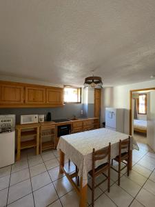une cuisine avec une table et des chaises dans une pièce dans l'établissement Maison Ste Foy Tarentaise, à Sainte-Foy-Tarentaise