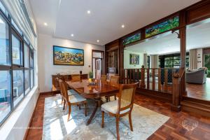 Deerpark Luxury Stays في نيروبي: غرفة طعام مع طاولة وكراسي خشبية