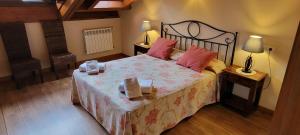 a bedroom with a large bed with pink pillows at Apartamentos Rurales Argame in Argamé