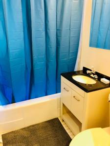 baño con lavabo y cortina de ducha azul en Stylish Montreal Apartment: Comfortable Stay in the Golden Square Mile, en Montreal
