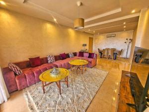 uma sala de estar com um sofá e duas mesas em appartement moderne au style beldi résidence au centre de Marrakech avec piscine em Marrakech