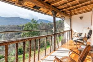 een balkon met stoelen en uitzicht op de bergen bij El nido de la golondrina in Llanes