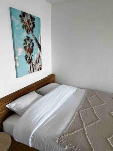 1 cama en un dormitorio con una foto en la pared en Trésor d’Anthéor, en Saint-Raphaël