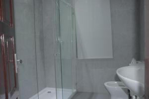 a bathroom with a shower and a toilet and a sink at Industria Villa in Ciudad de Malabo