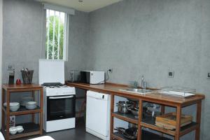 a kitchen with a counter and a stove and a sink at Industria Villa in Ciudad de Malabo