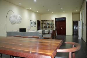 salon z drewnianym stołem i krzesłami w obiekcie Industria Villa w mieście Ciudad de Malabo