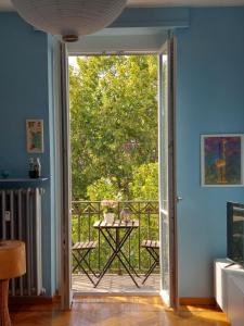 eine offene Tür, die auf einen Balkon mit einem Tisch führt in der Unterkunft Casa Turati in Turin